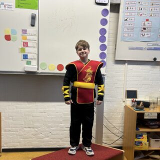 Kind in Kostüm steht auf Bühne